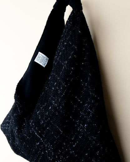 Vista laterale borsa Peggie con dettaglio reversibilità lamè e lana