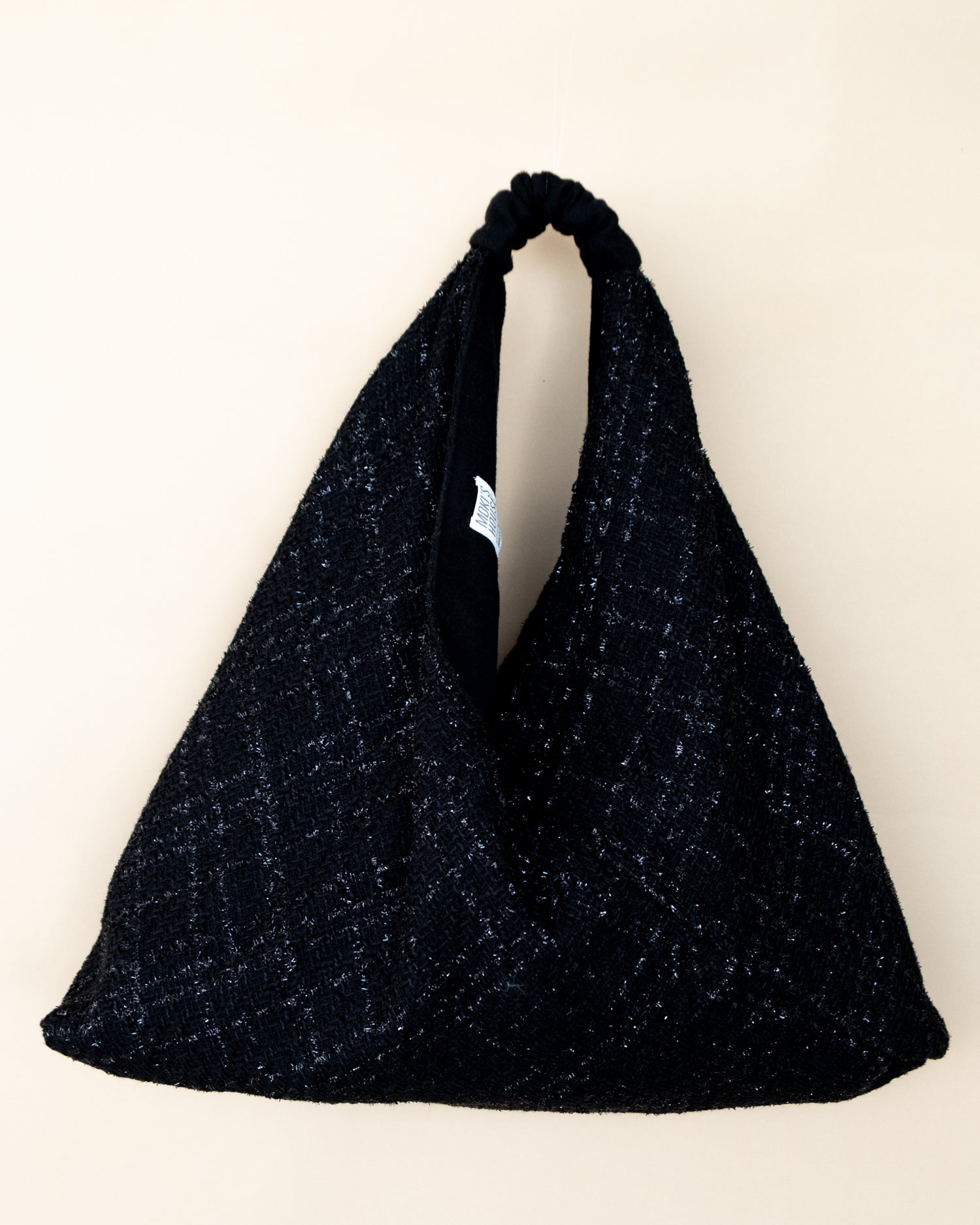 Borsa reversibile Peggie in lamè nero lucido e lana, vista frontale
