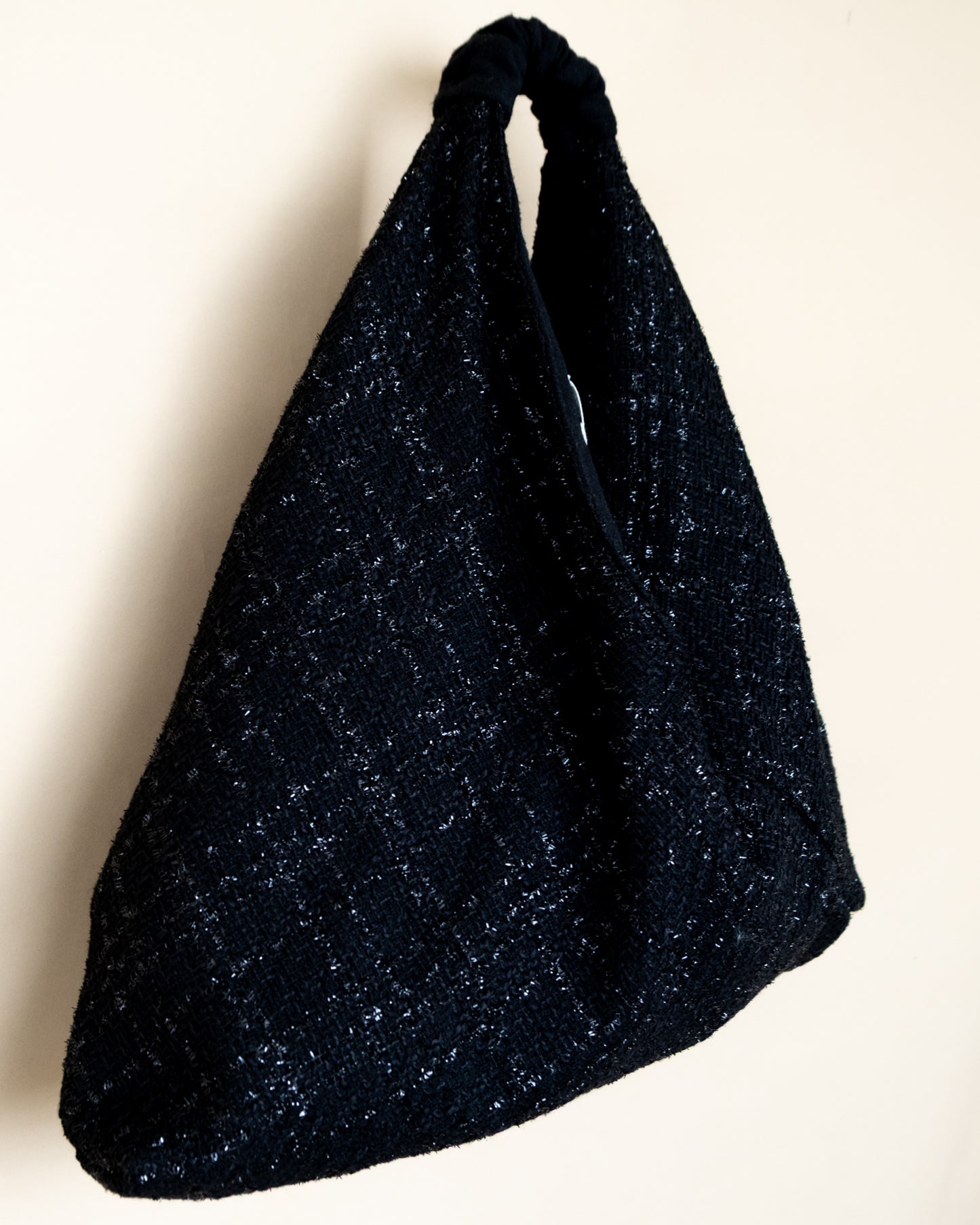 Vista laterale borsa Peggie con dettaglio reversibilità lamè e lana