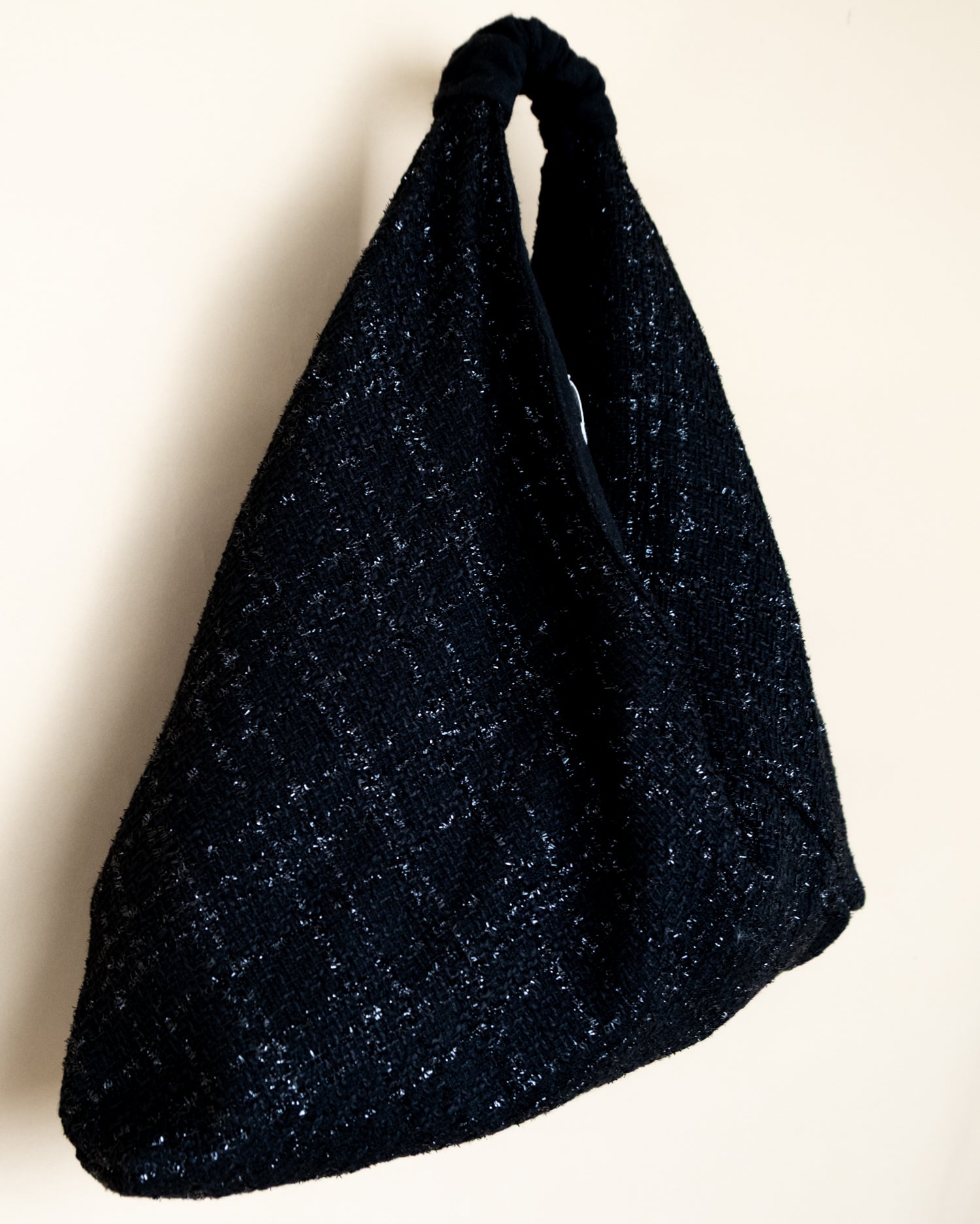 Vista laterale borsa Peggie con dettaglio reversibilità lamè e lana